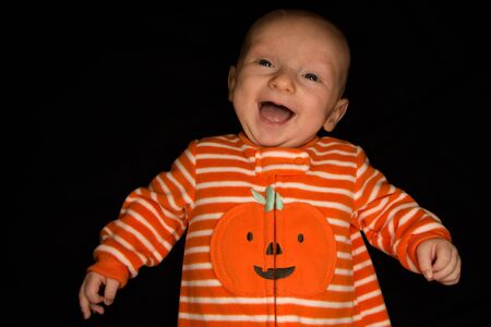 A Three Month Old Baby Poses on a Black Background. Perfect for Memes with Copy Space.の写真素材