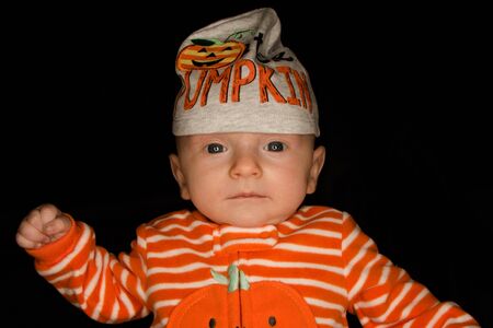 A Three Month Old Baby Poses on a Black Background. Perfect for Memes with Copy Space.の写真素材