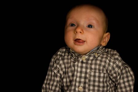 A 4 Month Old Baby Poses on a Black Background. Perfect for Memes with Copy Space.の写真素材