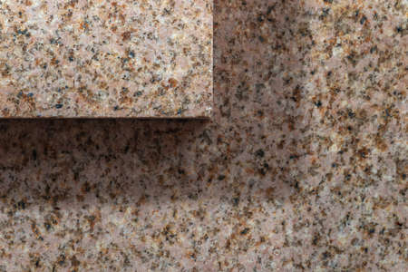 Smooth cut of the stone. Polished pink granite texture. Two layers of stone with shadow.の写真素材