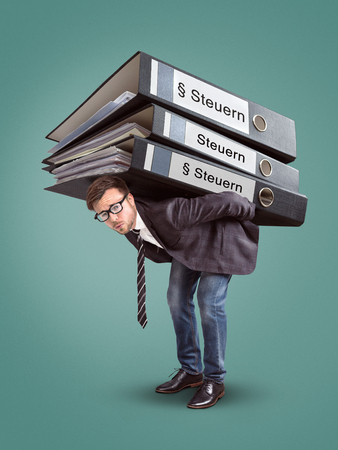 Man carrying a giant stack of tax foldersの写真素材