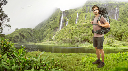 Hiker with backpack in front of a tropical waterfallの写真素材
