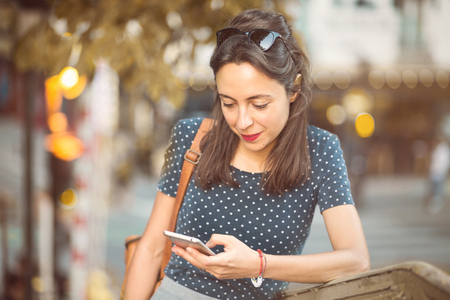 Italian girl looking at her smartphoneの写真素材