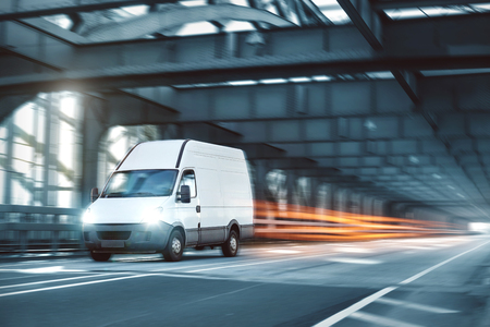 Van driving on a road through an industrial style bridgeの写真素材