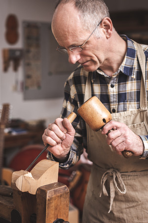 Wood sculptor working with chisel and malletの写真素材