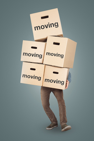 A man is carrying many moving boxes - isolated on a neutral backgroundの写真素材