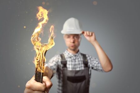 Craftsman holding a burning wrench toolの写真素材