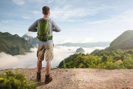 Hiker overlooking a valley filled with cloudsの写真素材