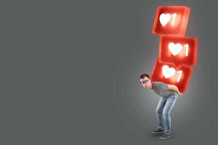 Man carrying a stack of large social media like symbolsの写真素材