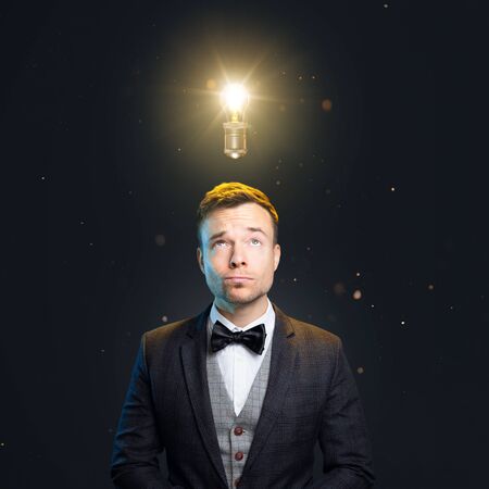 Well-dressed man with a light bulb above the headの写真素材