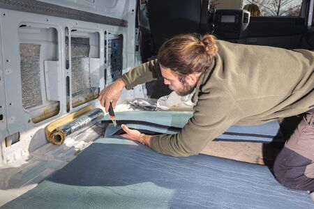 Man inside his camper van preparing insulation materialの写真素材