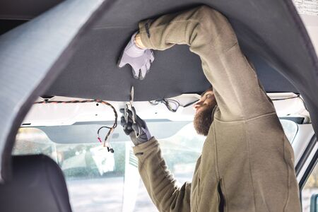 Man installing insulation inside his camper vanの写真素材