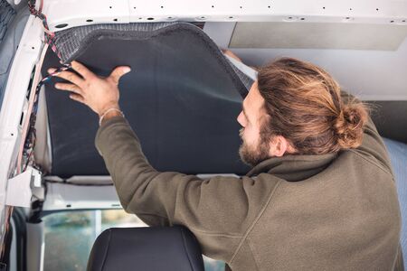 Man insulating the inside of his camper vanの写真素材