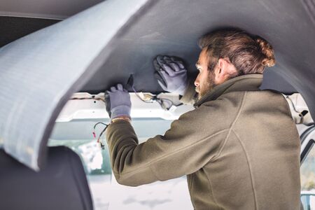 Man working on insulation inside his camper vanの写真素材