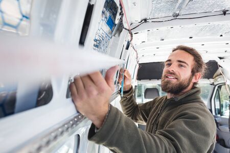 Man using a folding rule inside a vanの写真素材