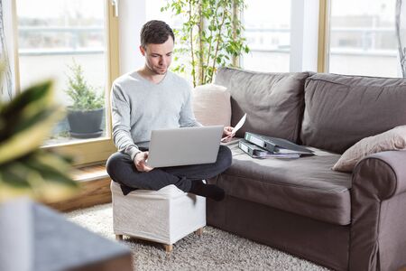 Man in living room working from homeの写真素材