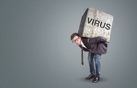 Man burdened by a stone labeled with VIRUSの写真素材
