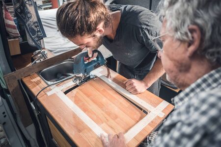 Father and adult son are crafting together