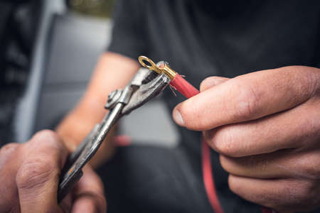 Man inside a van using heat shrink tubing on an electrical cable