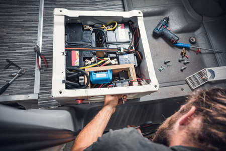Man inside a van using heat shrink tubing on an electrical cableの写真素材