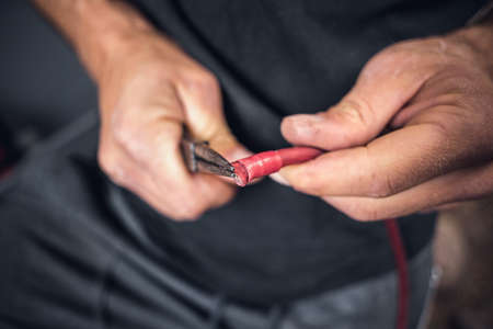 Man inside a van using heat shrink tubing on an electrical cableの写真素材