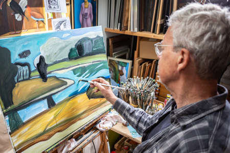 Senior artist painting in his studioの写真素材