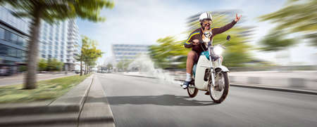 Funny man and his dog driving through the city on a motorcycleの写真素材