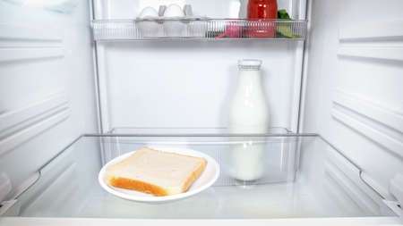 One lonely slice of bread inside an empty fridgeの写真素材