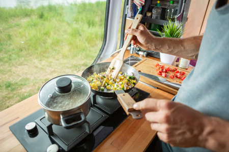 Cooking food on a stove inside a caravanの写真素材