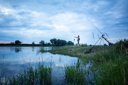 Angler on a river bank caught a fishの写真素材