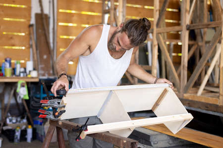 Man constructing a small cupboard for a caravanの写真素材