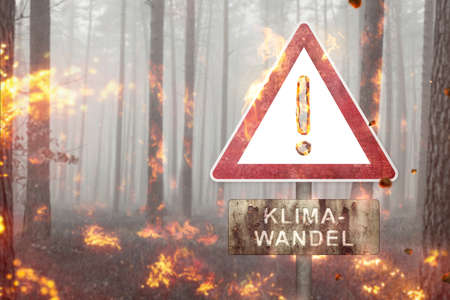 Climate change warning sign in a burning forestの写真素材
