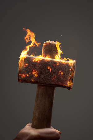 Old iron hammer on fire with copy spaceの写真素材
