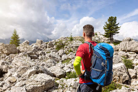 Hiker with a backpack standing in a field of rocksの写真素材