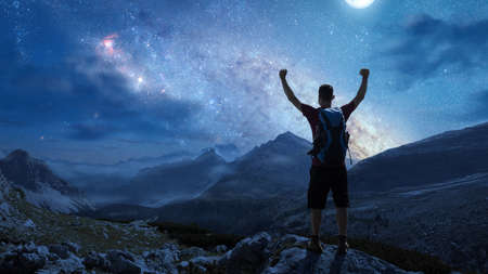 Hikers in the mountains under a starry night skyの写真素材