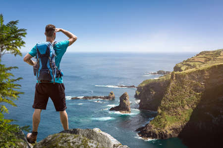 Hiker with a view over a scenic coastlineの写真素材