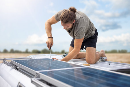 Person working on solar panels on top of a vanの写真素材