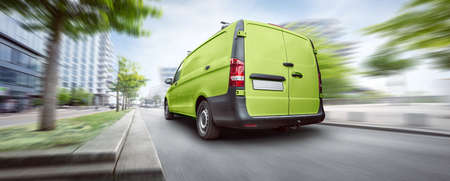 Green commercial van driving in the cityの写真素材