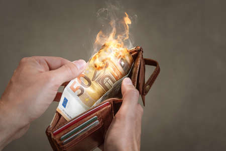 A burning 50 Euro bill in a wallet
