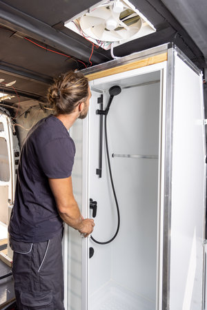 Man building a shower room inside a camper vanの写真素材