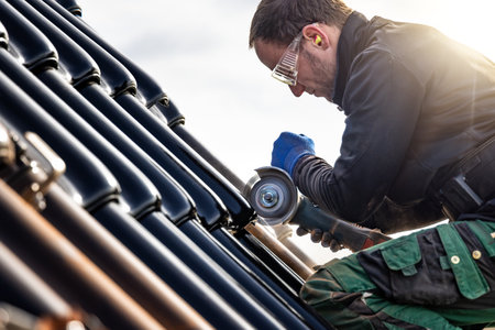Craftsman using an angle grinder on a tiled roofの写真素材