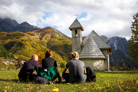 Small Group of Tourists Sitting on a Meadow in Theth, Albaniaの写真素材
