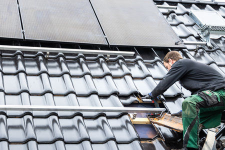 Technician Working on the Mounting Structure for Solar Panels on the Roof of a Houseの写真素材
