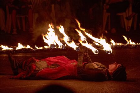 BUCHAREST, ROMANIA - SEPTEMBER 13: Lara Castiglioni juggles with burning torches while lying down during B-FIT in the Street, International Street Theater Festival on September 13, 2012 in Bucharest, Romania.のeditorial素材