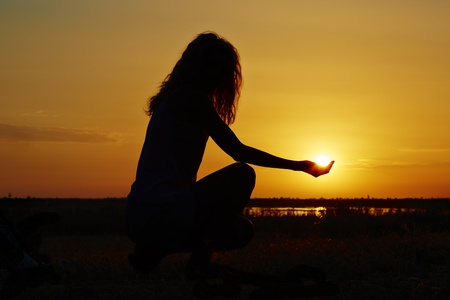 Silhouette of a woman having fun at sunset.