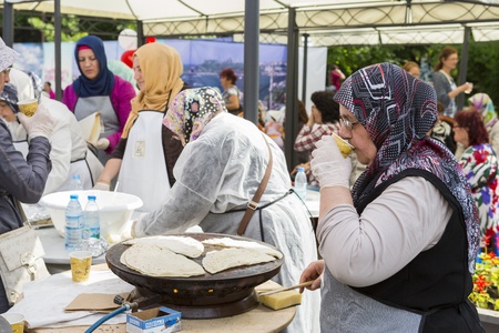 BUCHAREST, ROMANIA - MAY 17: Turkish woman cook bakes traditional suberek pie during the celebratory event Turkish Festival on May 17, 2013 in Bucharest, Romania.のeditorial素材