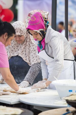 BUCHAREST, ROMANIA - MAY 17: Turkish women knead the dough for traditional suberek pie during the celebratory event Turkish Festival on May 17, 2013 in Bucharest, Romania.のeditorial素材