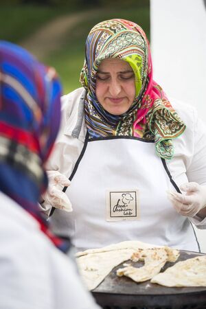 BUCHAREST, ROMANIA - MAY 17: Turkish women bake traditional suberek pie during the celebratory event Turkish Festival on May 17, 2013 in Bucharest, Romania.のeditorial素材