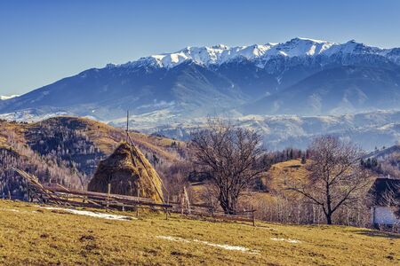Alpine rural landscape with sheepfold and haystack in the valleys of Bucegi mountains, Brasov...