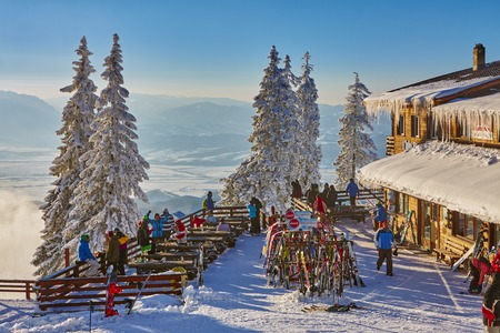 POIANA BRASOV, ROMANIA - FEBRUARY 11, 2015: Unknown skiers relax, dine and drink on the terrace of the Postavaru chalet, at 1604m altitude in Postavaru Mountain, Poiana Brasov resort, Brasov county.のeditorial素材